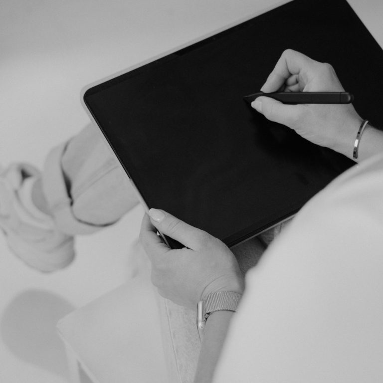 Aufzeichnung von Notizen Eine Person zeichnet mit einem Stift auf ein Tablet, während sie sitzt.