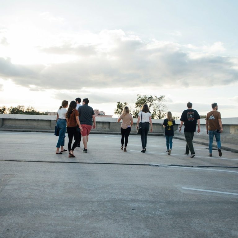 Eine Gruppe von Personen läuft auf einer Dachterrasse in den Sonnenuntergang.